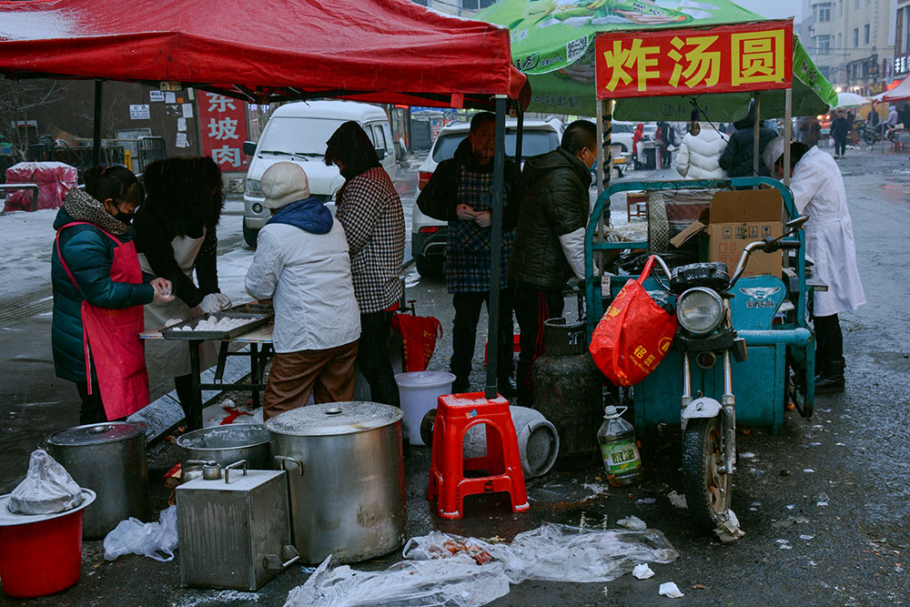 雪后傍晚路口炸汤圆